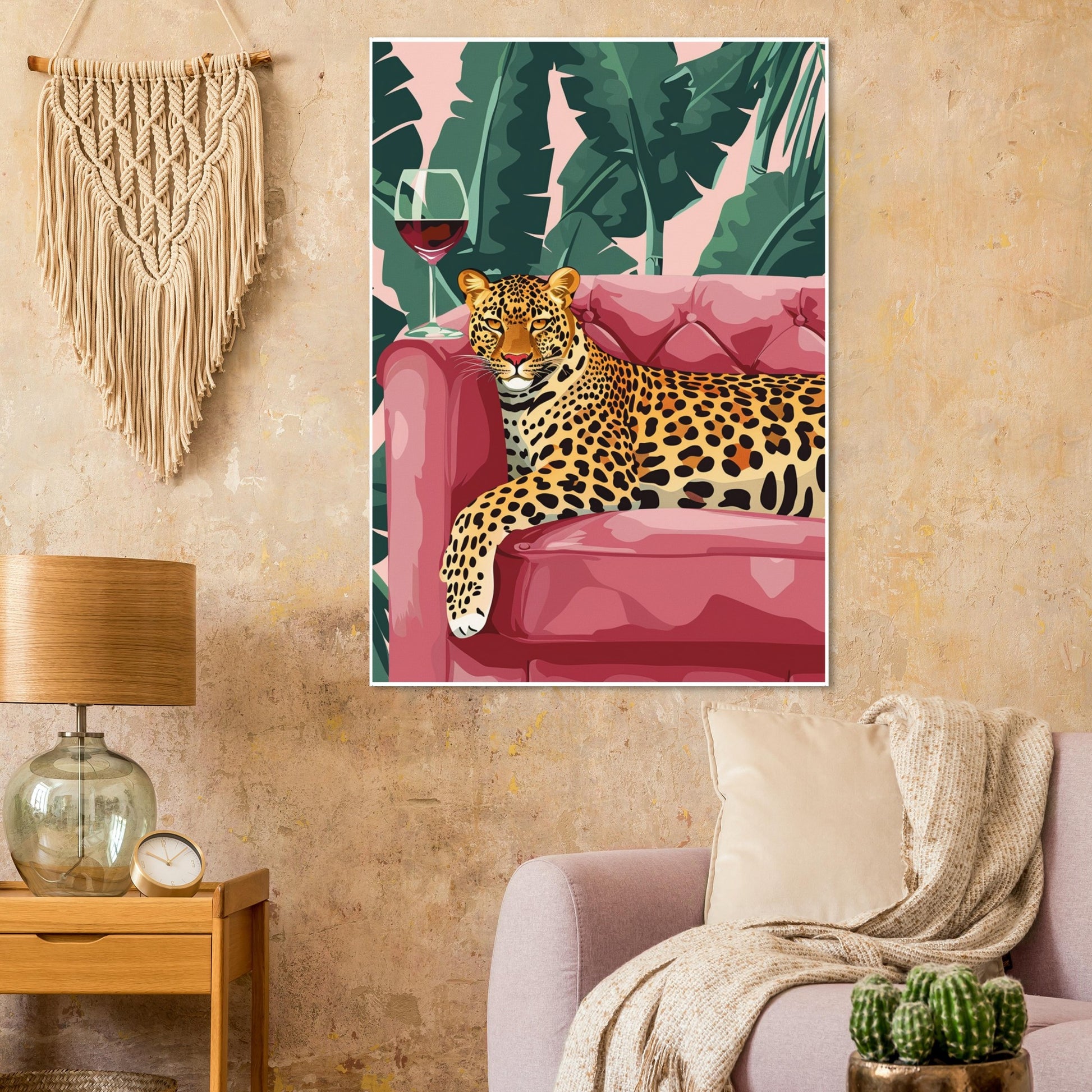 Framed Tropical Lounge Leopard artwork displayed in a warm living room with soft natural light. The print shows a golden leopard on a pink sofa surrounded by lush jungle foliage. Tropical colours and bold composition create a striking statement piece that adds confidence, luxury, and modern vibrance to eclectic, contemporary interiors.
