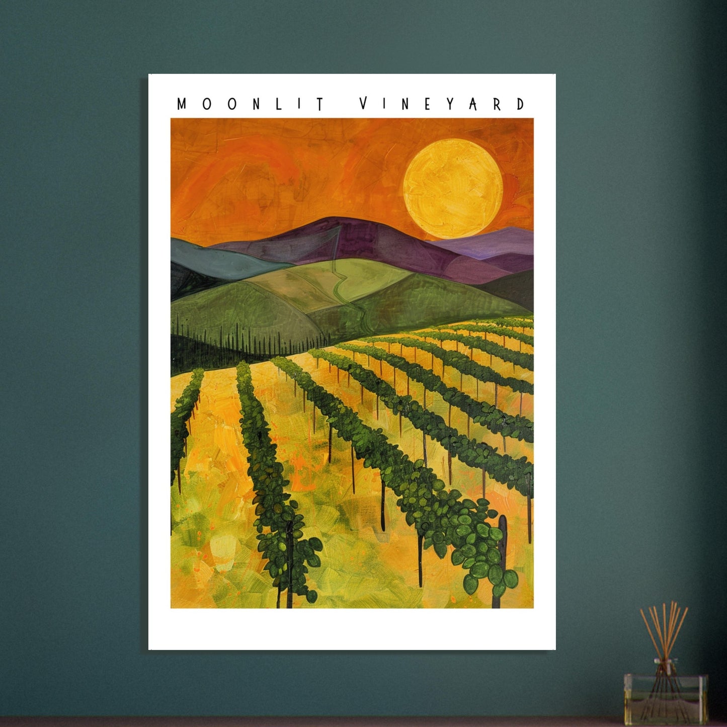A framed Moonlit Vineyard landscape print displayed above a modern green-accented interior with plants and soft lighting. The warm golds and deep purples of the artwork contrast beautifully with the earthy décor, creating a rich, atmospheric focal point perfect for dining rooms, living spaces, or home bars seeking a cosy, rustic-modern feel.